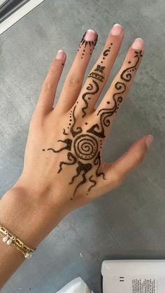 a woman's hand with henna tattoos on it
