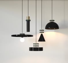 three black lamps hanging from the ceiling in a room with white walls and flooring