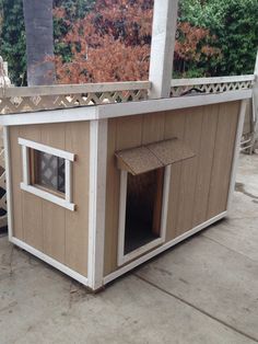 a dog house that is made out of wood and has a roof over the door