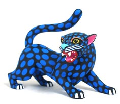 a blue and black leopard figurine with spots on it's body, showing its teeth