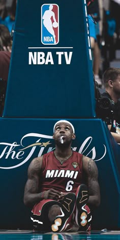 a man sitting on top of a basketball court