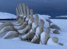 the snow covered rocks are stacked together