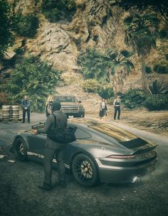 a man standing next to a car on a road