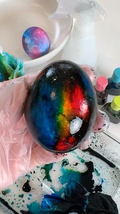a marble ball sitting on top of a table next to paint and other craft supplies