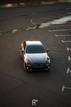 the car is driving down the road in the parking lot with no one around it