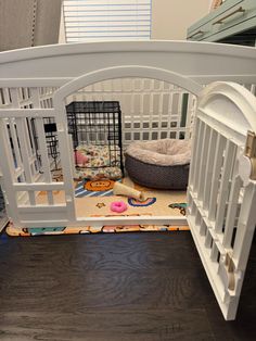 a dog kennel with its door open and toys on the floor next to it