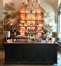 an elegant bar with chandelier and wine bottles