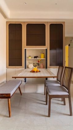 a dining room table with two chairs and a bench