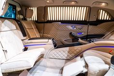 the interior of a luxury car with all white leather and blue trimmings on it
