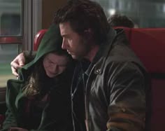 a man and woman sitting next to each other on a train