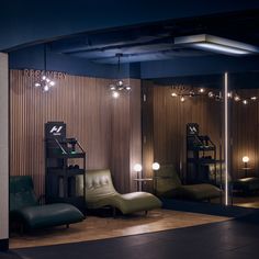 a room with chairs, lights and mirrors in it's center area is lit up at night