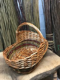 a wicker basket sitting on top of a wooden table next to some grass stalks