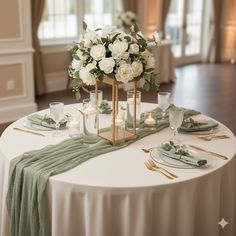 a table set with white flowers and candles