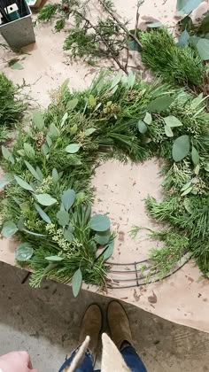 someone is making a wreath out of greenery