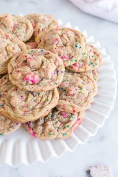 sprinkled cookies on a white plate with pink and green sprinkles