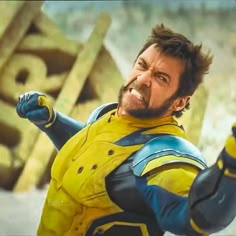 a man dressed in yellow and blue is holding his fist up to the air while smiling