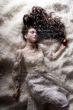 a woman laying on top of a bed covered in snow