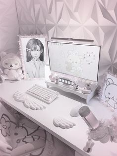 a desk with a computer, teddy bear and other items on it in front of a wallpapered background