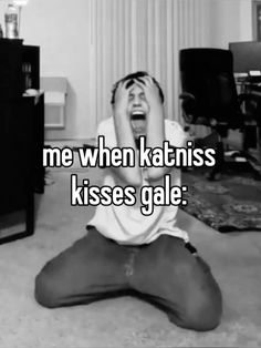 a person sitting on the floor with their head in their hands and texting me when katniss kisses gale