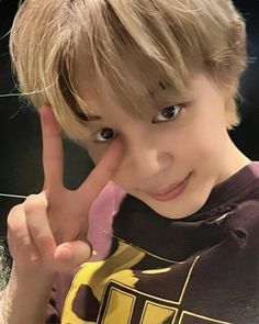 a young boy making the v sign with his fingers