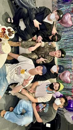 a group of people standing next to each other in front of a table with food on it