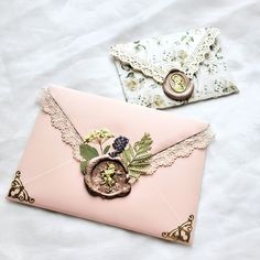 two envelopes with lace and flowers on them