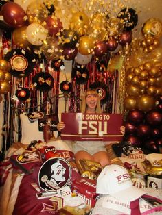 a man laying in bed holding a sign that says going to fsu