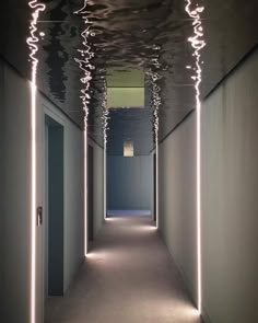 an empty hallway with lights on the ceiling
