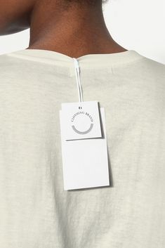 the back of a woman's shirt with a white tag attached to her chest