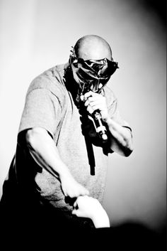 a man wearing a gas mask holding a microphone