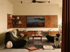 a living room filled with furniture and a flat screen tv mounted to the side of a wall