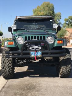 a green jeep is parked on the street