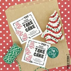 two small christmas trees sitting on top of a piece of paper next to twine spools