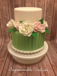 a green and white cake with flowers on top