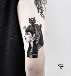 an egyptian style tattoo on the arm