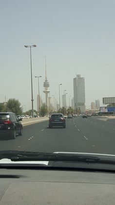 cars are driving down the highway near tall buildings