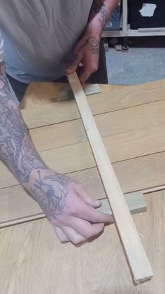 a man working on some wood with his hands