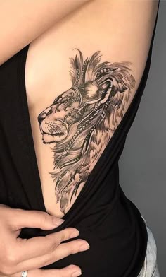 a woman with a lion tattoo on her back and shoulder, showing the lower part of her stomach