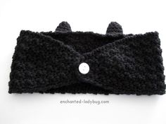 there is a black knitted headband with buttons on the front and back side