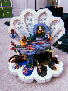 there is a large shell shaped building made out of legos and other toys on the floor