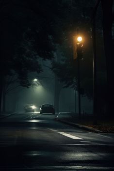 a car driving down a street at night with headlights on and fog in the air