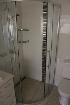 a bathroom with a toilet, shower and stand up shower stall in it's corner