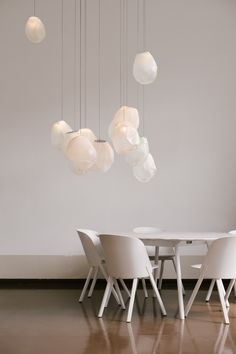 a white table and chairs in a room with lights hanging from it's ceiling