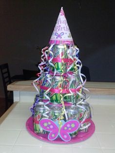 a birthday cake made out of cans with a butterfly on top and streamers around it