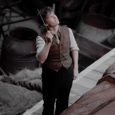 a man holding an umbrella while standing next to a building