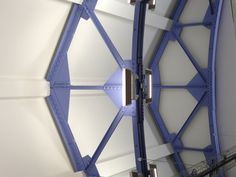 an overhead view of a building with blue and white paint on the ceiling, lights are hanging from the rafters