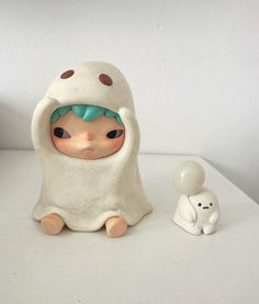 a ceramic figurine is sitting next to a small toy