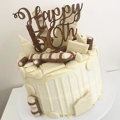 a birthday cake with white frosting and chocolate decorations