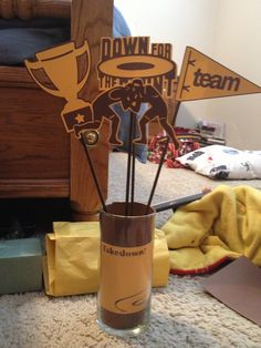 a vase filled with sticks sitting on top of a carpet