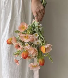 a person holding a bouquet of flowers in their hand